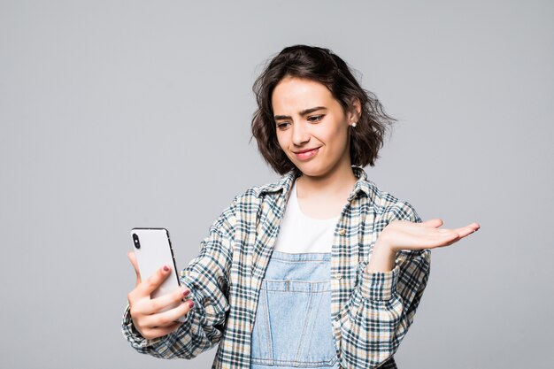 Retrato de niña bonita disparando autorretrato en el teléfono inteligente, con la palma abierta