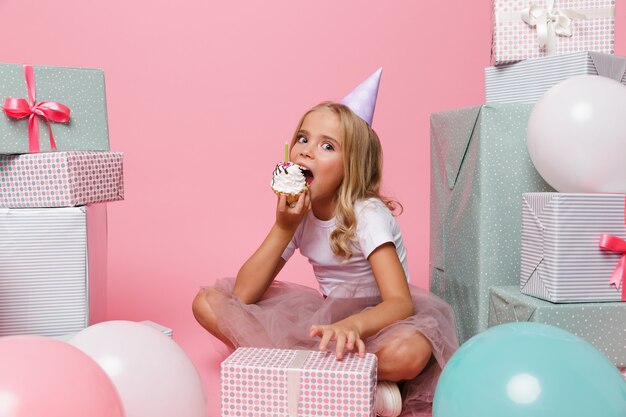 Retrato de una niña bonita con un sombrero de cumpleaños