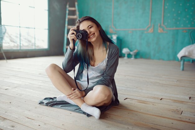 Retrato de niña bonita tomando foto en la cámara de cine