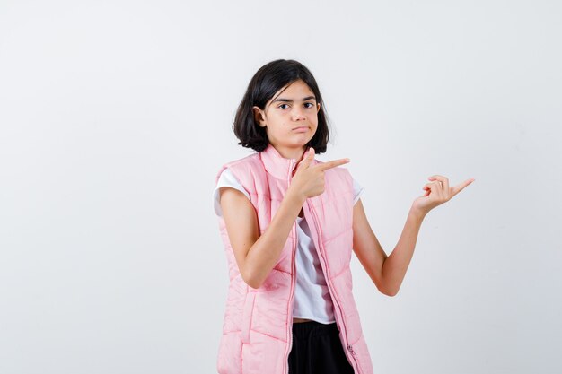 Retrato de una niña en camiseta blanca y chaleco acolchado hacia la derecha