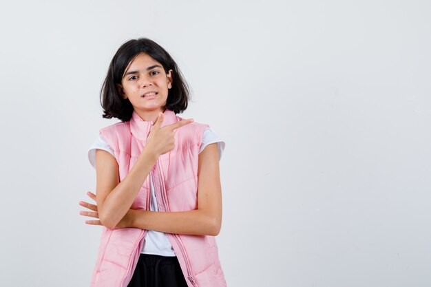 Retrato de una niña en camiseta blanca y chaleco acolchado hacia la derecha