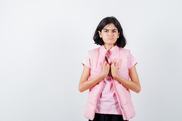 Retrato de una niña en camiseta blanca y chaleco acolchado