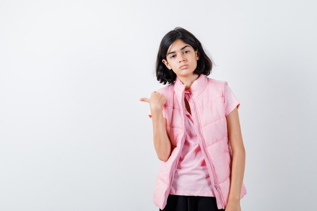 Retrato de una niña en camiseta blanca y chaleco acolchado