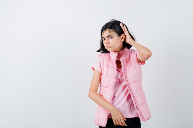 Retrato de una niña en camiseta blanca y chaleco acolchado