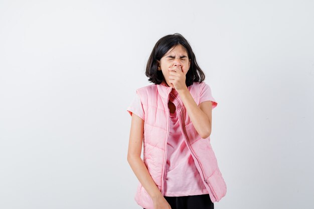 Retrato de una niña en camiseta blanca y chaleco acolchado