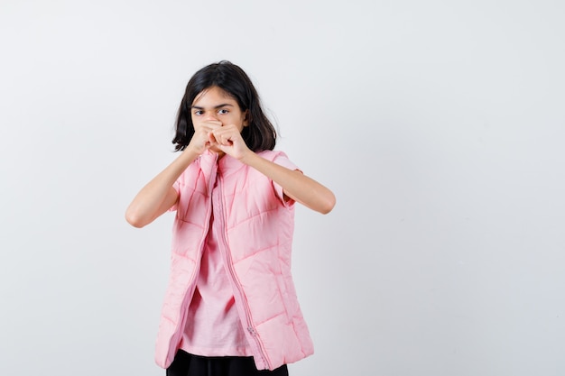 Retrato de una niña en camiseta blanca y chaleco acolchado