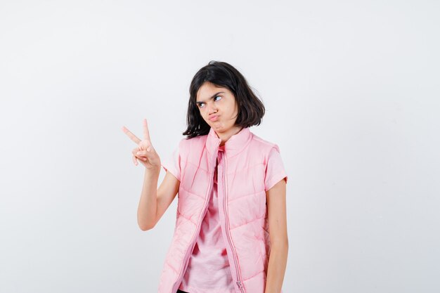 Retrato de una niña en camiseta blanca y chaleco acolchado