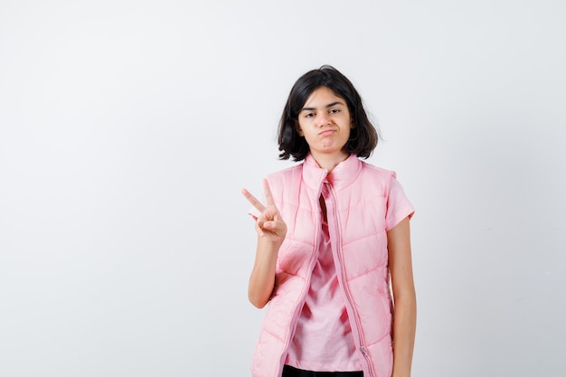 Retrato de una niña en camiseta blanca y chaleco acolchado