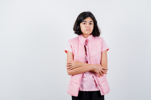 Retrato de una niña en camiseta blanca y chaleco acolchado