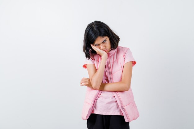 Retrato de una niña en camiseta blanca y chaleco acolchado