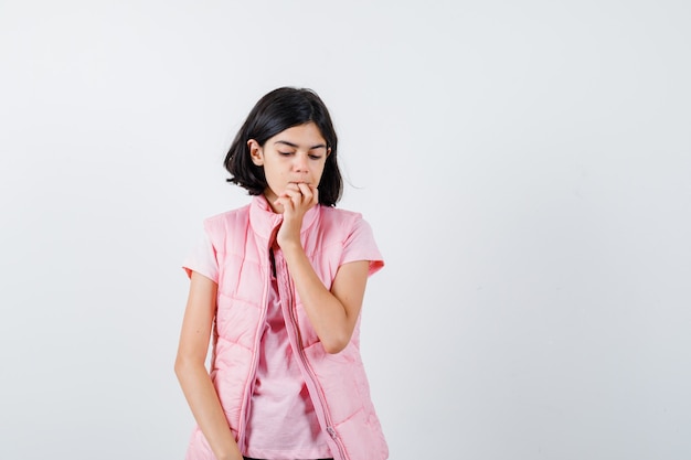 Retrato de una niña en camiseta blanca y chaleco acolchado