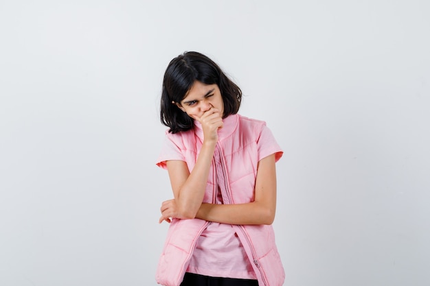 Retrato de una niña en camiseta blanca y chaleco acolchado