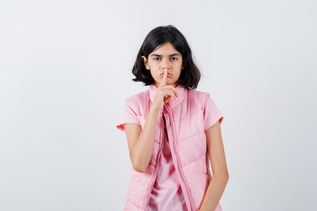 Retrato de una niña en camiseta blanca y chaleco acolchado