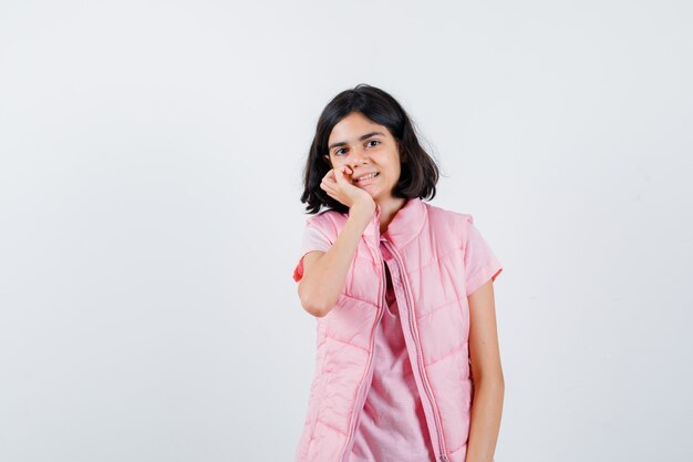 Retrato de una niña en camiseta blanca y chaleco acolchado