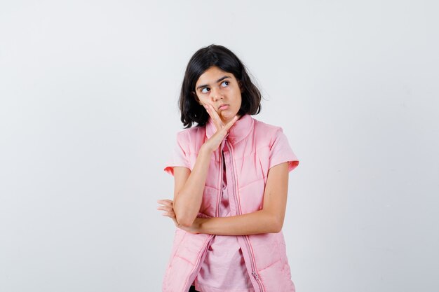 Retrato de una niña en camiseta blanca y chaleco acolchado