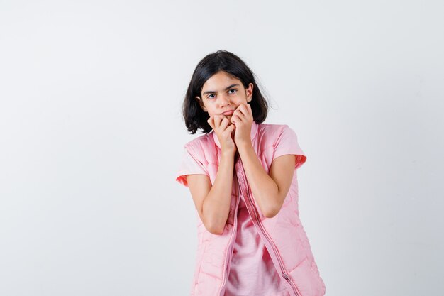 Retrato de una niña en camiseta blanca y chaleco acolchado