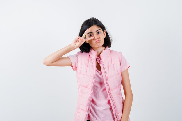 Retrato de una niña en camiseta blanca y chaleco acolchado