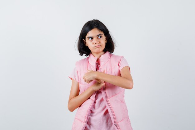 Retrato de una niña en camiseta blanca y chaleco acolchado