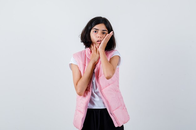 Retrato de una niña en camiseta blanca y chaleco acolchado