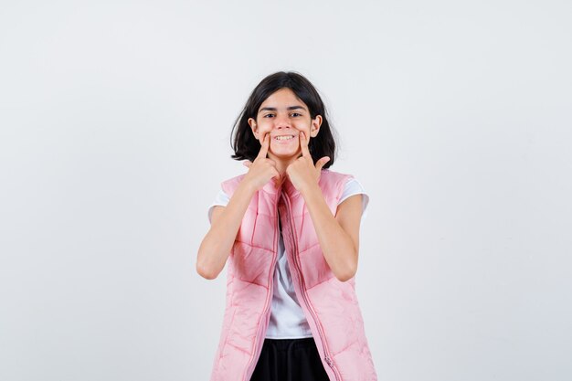 Retrato de una niña en camiseta blanca y chaleco acolchado