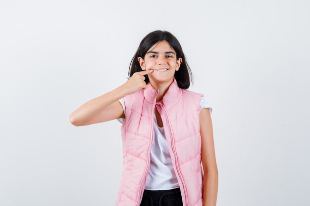 Retrato de una niña en camiseta blanca y chaleco acolchado