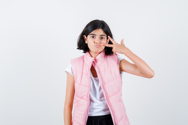 Retrato de una niña en camiseta blanca y chaleco acolchado