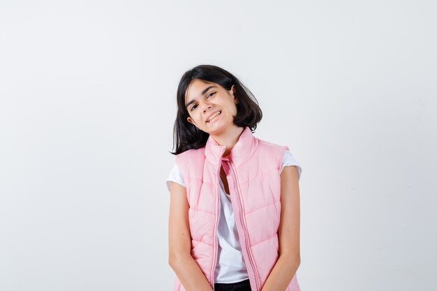 Retrato de una niña en camiseta blanca y chaleco acolchado