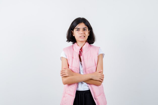 Retrato de una niña en camiseta blanca y chaleco acolchado