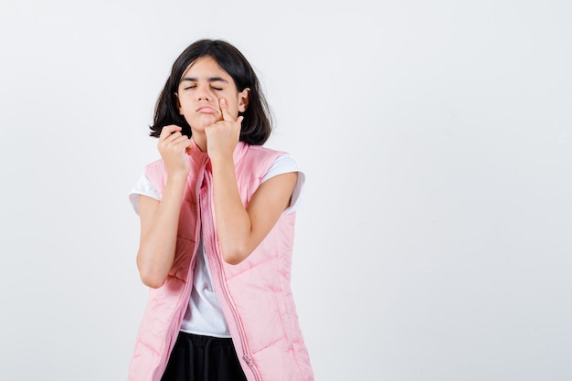 Retrato de una niña en camiseta blanca y chaleco acolchado