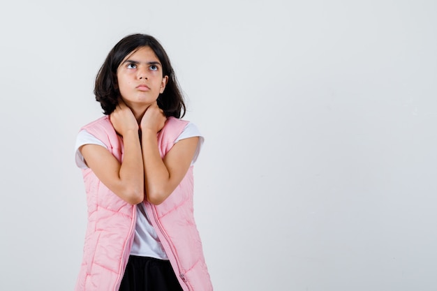 Retrato de una niña en camiseta blanca y chaleco acolchado