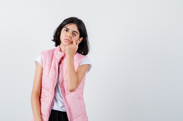 Retrato de una niña en camiseta blanca y chaleco acolchado