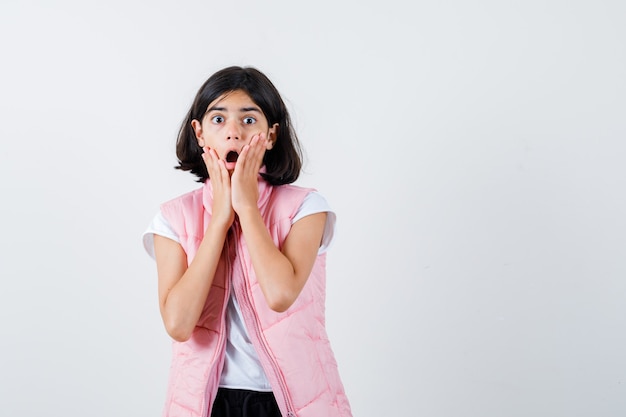 Retrato de una niña en camiseta blanca y chaleco acolchado