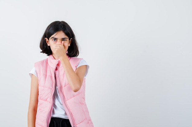 Foto gratuita retrato de una niña en camiseta blanca y chaleco acolchado