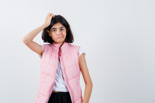 Retrato de una niña en camiseta blanca y chaleco acolchado