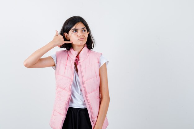 Retrato de una niña en camiseta blanca y chaleco acolchado