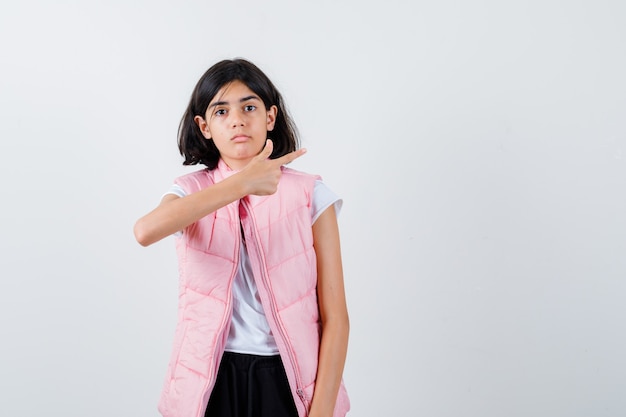 Retrato de una niña en camiseta blanca y chaleco acolchado