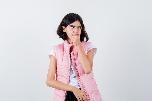 Retrato de una niña en camiseta blanca y chaleco acolchado