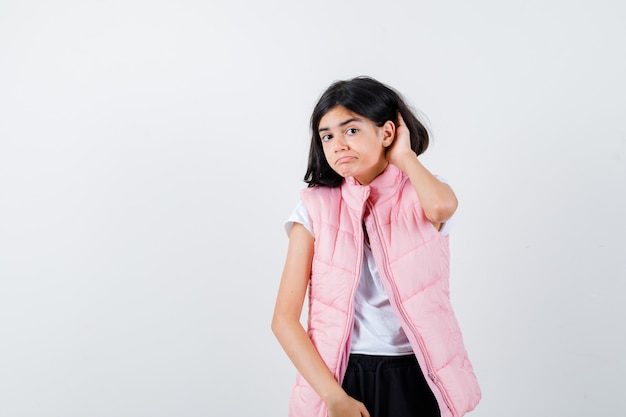 Foto gratuita retrato de una niña en camiseta blanca y chaleco acolchado