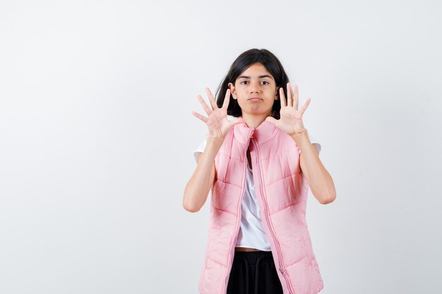 Retrato de una niña en camiseta blanca y chaleco acolchado