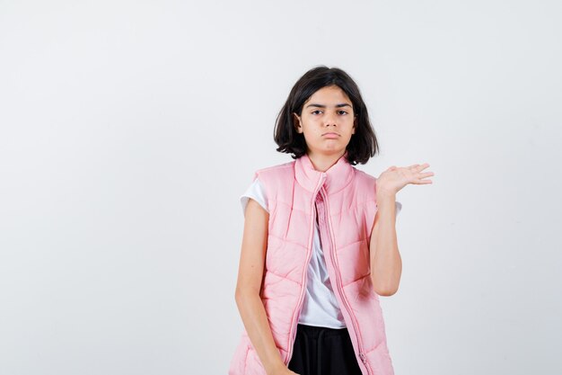 Retrato de una niña en camiseta blanca y chaleco acolchado