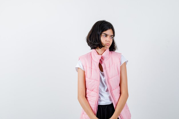 Retrato de una niña en camiseta blanca y chaleco acolchado