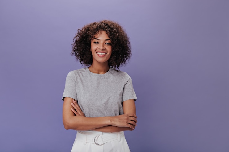 Foto gratuito retrato de niña en camiseta gris en la pared púrpura