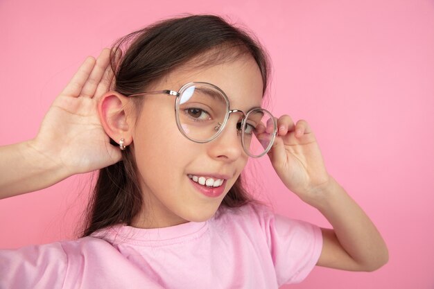 Retrato de niña caucásica aislado en estudio rosa, concepto de emociones