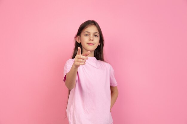 Retrato de niña caucásica en pared rosa