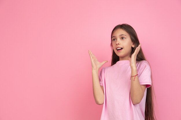 Retrato de niña caucásica en pared rosa