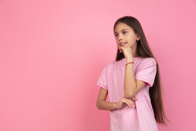 Retrato de niña caucásica en pared rosa