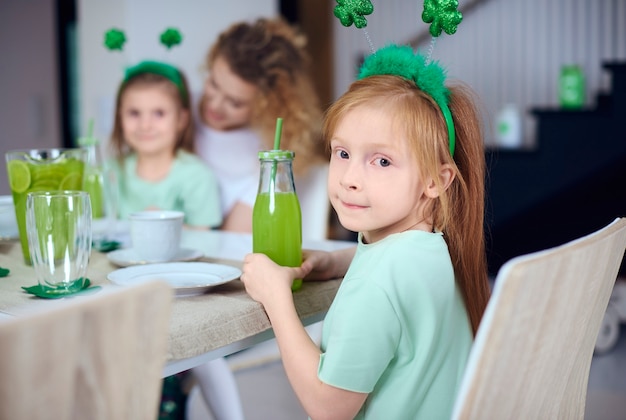 Retrato de niña con cóctel en la mesa