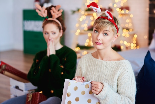 Retrato de niña disgustada abriendo regalo de navidad