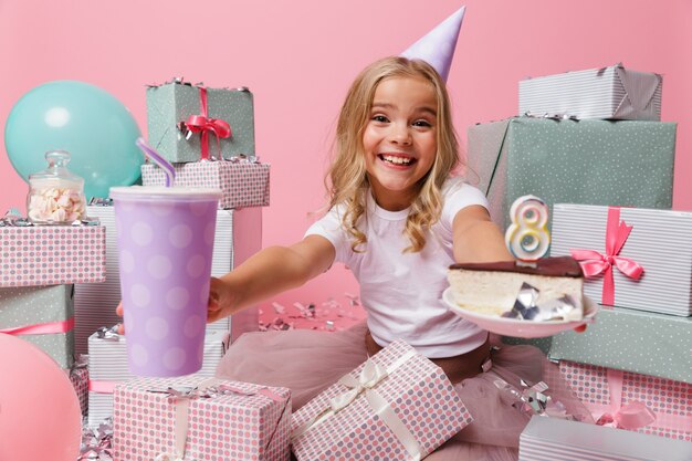Retrato de una niña emocionada en un sombrero de cumpleaños