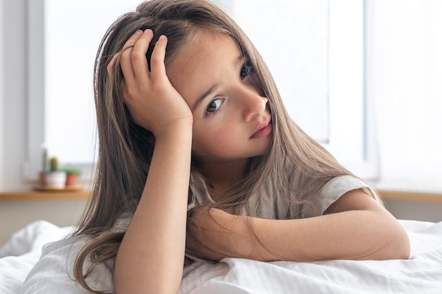 Retrato de una niña encantadora en la cama temprano en la mañana